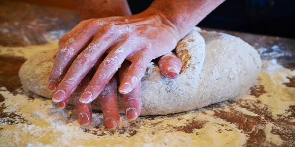 The Baker A baker kneading fresh dough with their hands